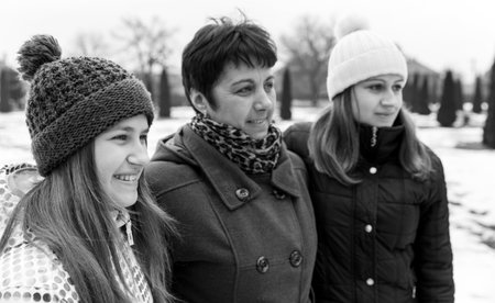 Photo of happy mother with daughters walking in the parkの写真素材