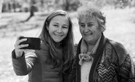 Photo of happy elderly woman with her daughter taking selfie