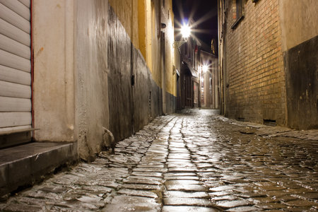 Old wet cobblestone street after rain at nightの写真素材