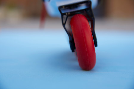 Close-up of the rear wheel of inclined inline skates walking on blue background with copyspaceの写真素材
