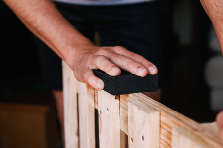 Unrecognizable man's hand sanding a pallet. home renovationの写真素材