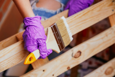 Close-up unrecognizable woman's hands with purple gloves painting a pallet with a brush. Reformsの写真素材