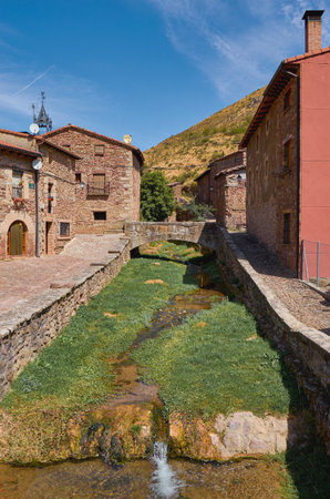 Stream flowing through the middle of an old town in Spain.の写真素材