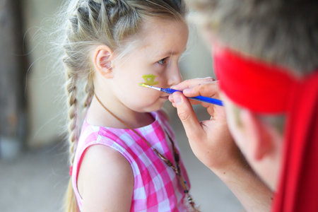 Adorable girl getting her face paintedの写真素材