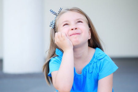 Adorable girl dreaming and thinking about future and presentsの写真素材