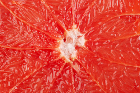 Sliced pink grapefruit closeup macro shot as a background or wallpaper