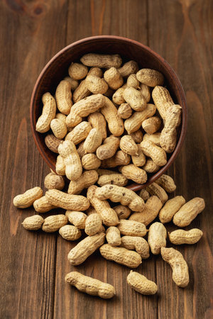 Peanuts in a bowl on wooden background
