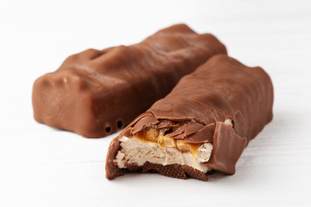 Two chocolate ice cream bars with caramel and peanuts on white background close up macro shotの写真素材