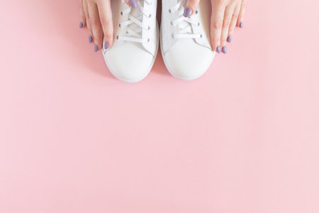 All white sneakers on pink background. Top view, flat lay