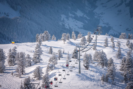 Skiers on skilift with frost trees montains. Ski resort in Europeの写真素材