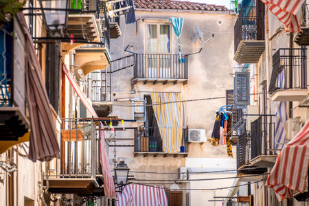 CEFALU, ITALY - October 02, 2019: Old town street with balconies and clothesのeditorial素材