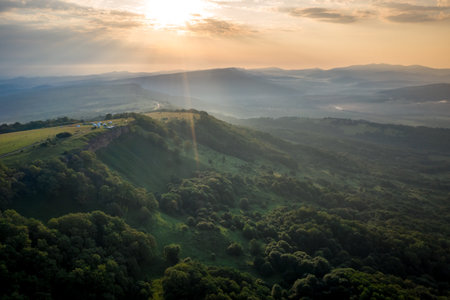 Early morning in the mountains. Morning sun and haze in the valley against the background of mountainsの写真素材