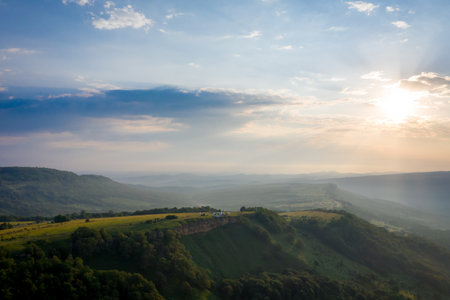 Early morning in the mountains. Morning sun and haze in the valley against the background of mountainsの写真素材