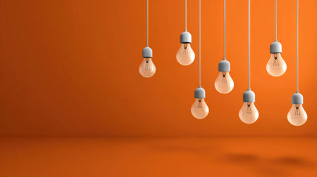 This image features a collection of hanging light bulbs against a warm orange background. The cozy atmosphere is perfect for interior design projects, showcasing modern elegance and creativity.の素材