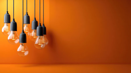 A stunning arrangement of pendant light fixtures against a bold orange wall, creating a warm atmosphere ideal for modern interior spaces.の素材