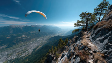 Experience the thrill of paragliding with a breathtaking view of majestic mountains and valleys under a bright blue sky, showcasing nature's beauty.の素材