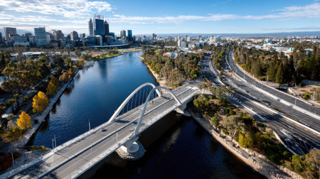 Stunning aerial view showcasing the harmonious blend of nature and urban life with a river, modern architecture, and clear sky in a vibrant city setting.の素材