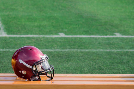 Football helmet on a bench, football field in the background
