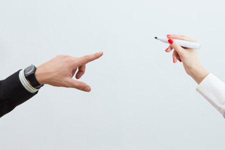 Female hand is ready for drawing with marker. Male hand pointing with forefinger. Isolated on white. の写真素材