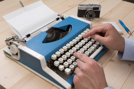 Journalist working on typewriter at his desk. No recognizable person.の写真素材