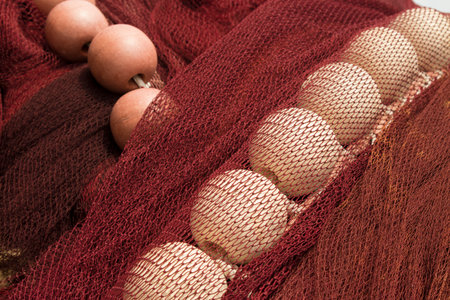 Close-up of white fishing floats on red drift net    