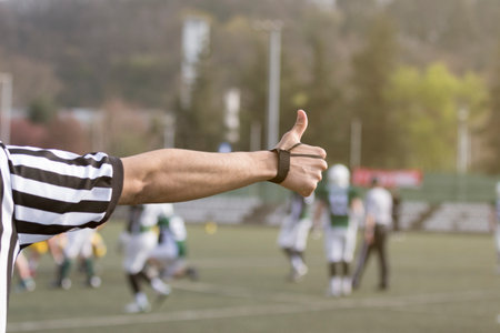 Hand of football referee showing signal with his thumb up の写真素材