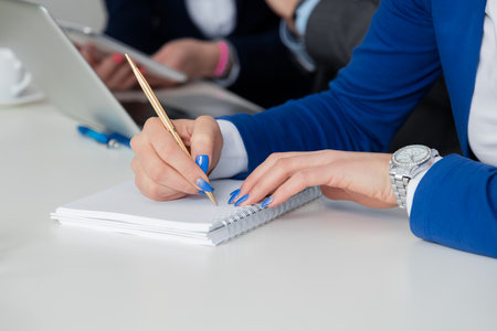 Businesswoman taking notes at seminar. Close up of a hand writing in the notebook.  の写真素材