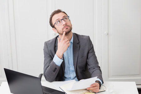 Young business professional is conceived and thinking how to solve next business challengeの写真素材