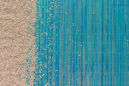 Combination of sand and blue bamboo mat background. Summertime concept. Space for copy and elements adding.    の写真素材