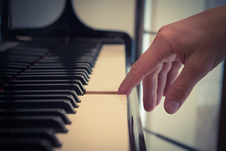 Close up of pianist forefinger touching piano key.     の写真素材