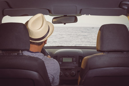 Tourist driving car. Sea in the background. の写真素材