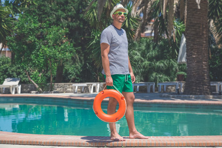 Portrait of yong tourist holding lifebuoy at the poolsideの写真素材