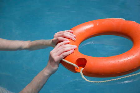 Close up of woman hands holding lifebelt in sea. Emergency drowning help conceptの写真素材