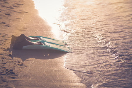 Snorkel fins on sandy beach and sea. Space for copy.の写真素材