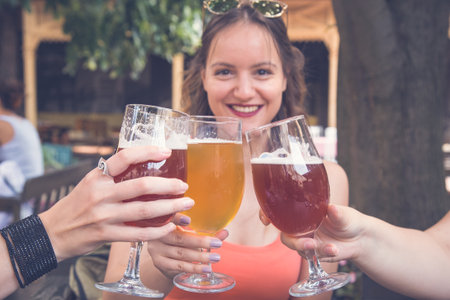 Female toasting and cheering aperitif beers half pint with her friends at restaurantの写真素材