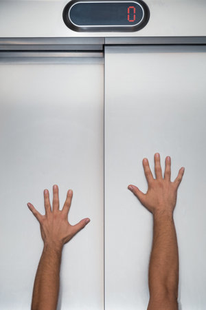 Man hands try to stop and prevent closing elevator door