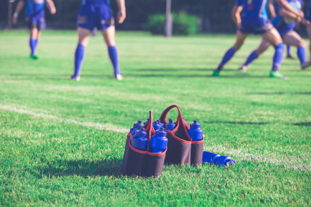 Sport bottles of fresh water energy drink on football rugby field grassの素材 [FY31097104521]