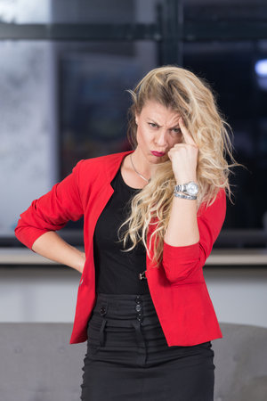 Portrait of unhappy businesswoman with forefinger on her forehead.の写真素材