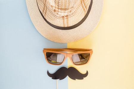 Hipster guy minimal concept. Hat, sunglasses and mustache paper prop flat lay.の写真素材