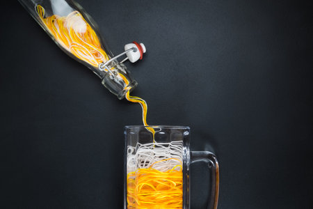 Flat lay of pouring yellow and white threads in form of beer from bottle to beer mug minimalistic creative concept. Space for copy.の写真素材