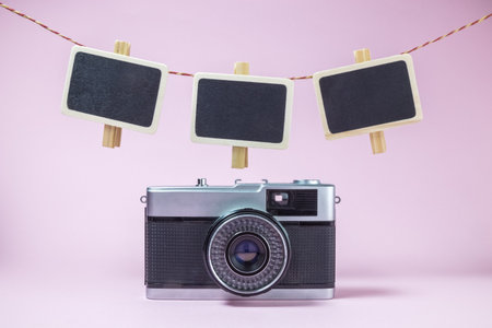 Retro camera and clothespins with blank photo frames on rope minimal conceptの写真素材