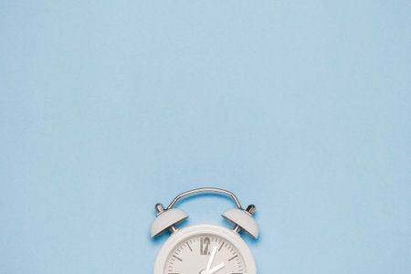 White clock on pastel blue background. Space for copy. Minimal concept.
