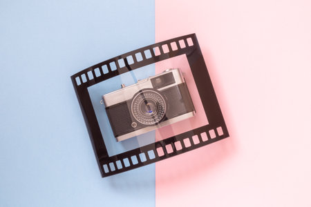 Retro film camera and photo frame isolated on colorful pastel background minimal creative concept.の写真素材