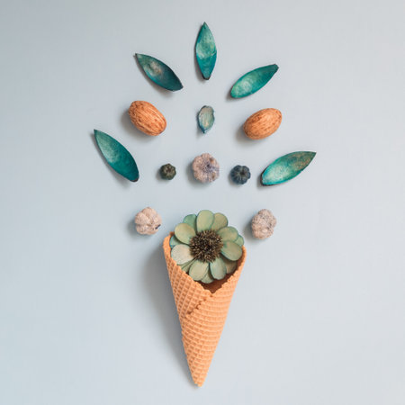 Ice cream cone with dried flowers flat lay on pastel blue background minimal creative spring and summer concepts.の写真素材