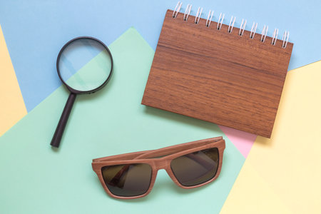 Magnifying glass, notebook and sunglasses on colorful pastel background minimal creative concept.の写真素材