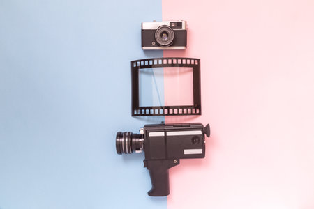 Retro vintage analog film camcorder, photo camera and picture frame on pastel background minimal technology creative concept.の写真素材