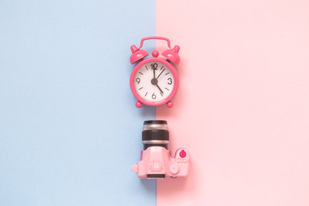Flat lay of dslr camera toy and small alarm clock on pastel background minimal creative concept.の写真素材