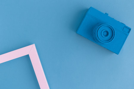 Retro film photo camera colored in blue with photo frame minimal abstract creative concept. Space for copy.の写真素材