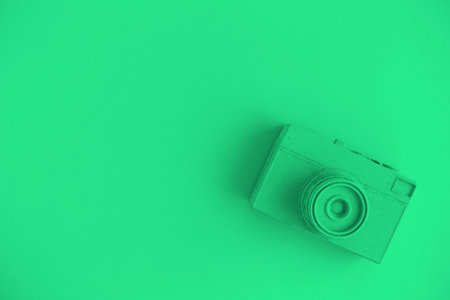 Vintage camera on background in neon green color minimal creative art concept. Space for copy.