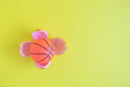 Basketball ball in orange peel on blue background. Sport and healthy lifestyle minimal concept. Space for copy.の写真素材